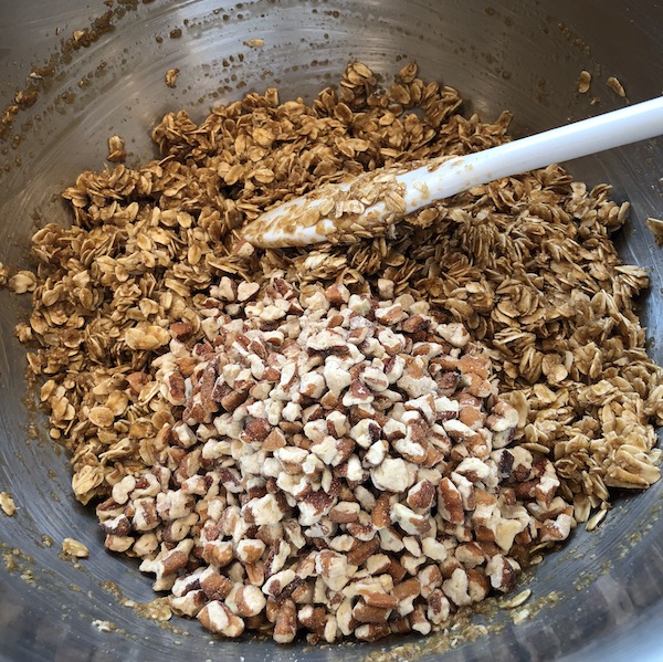 chopped pecans sitting on top of mixed wet and dry ingredients