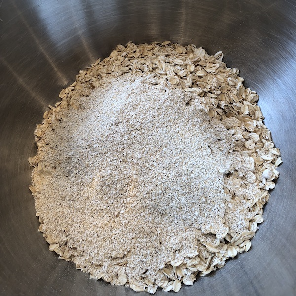 Oatmeal and oat bran in a large stainless steel bowl