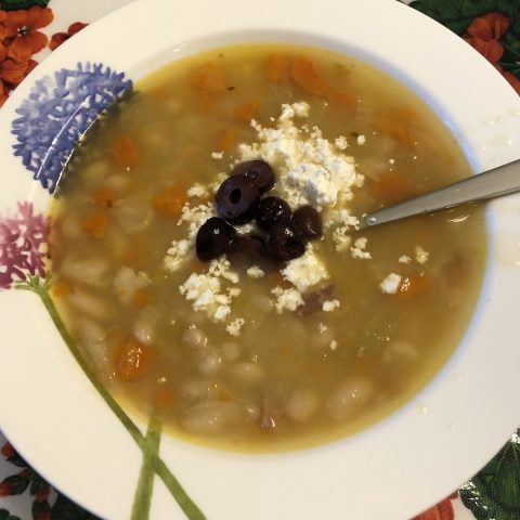Tuscan Beans in a bowl with crumbled goat cheese & sliced kalamata olives