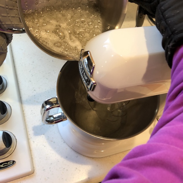 Pouring hot sugar mixture into mixer bowl