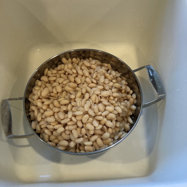 soaked great northern beans in colander in sink