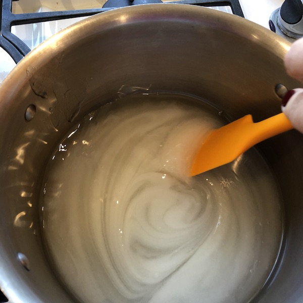 Stirring the sugar and water in pan