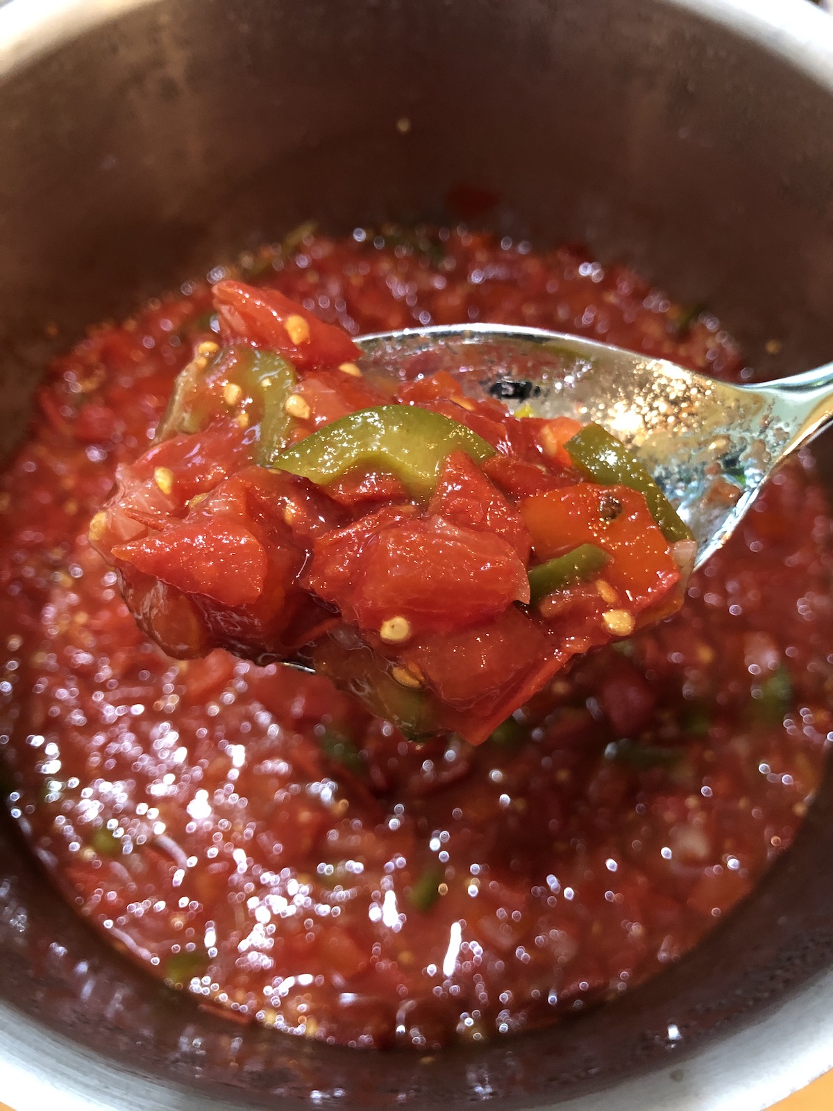 Fresh Corn Tomato Salad in a clear glass bowl on a white counter.