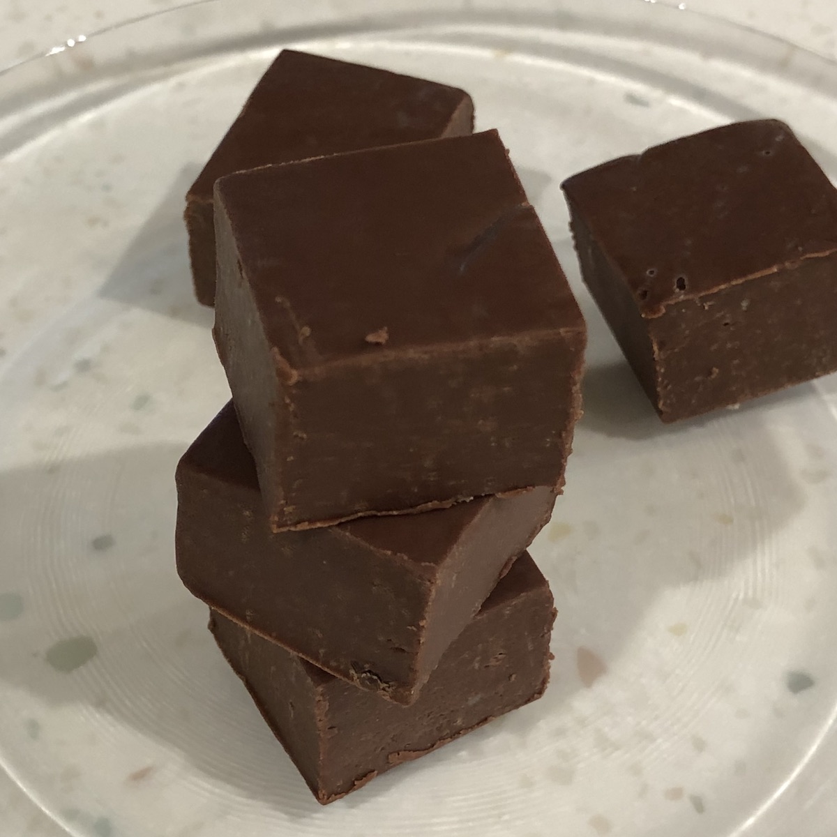 5 pieces fudge (3 stacked) on a clear plate