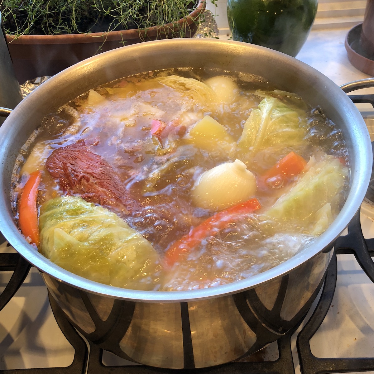 Corned beef, potatoes, carrots & cabbage boiling in a large stock pot