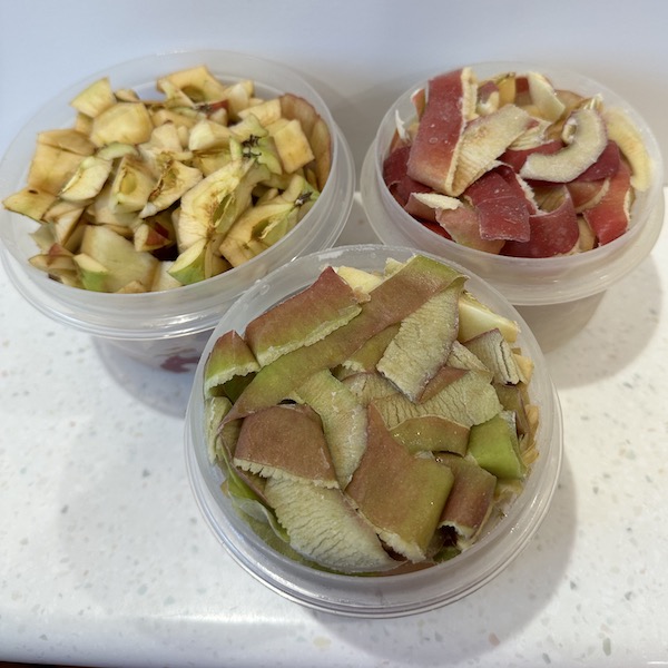 3 containers filled with frozen apple peels and cores