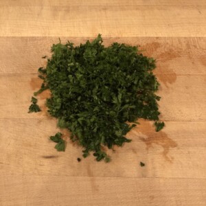 chopped parsley on wooden cutting board