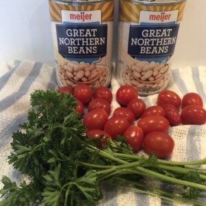 canned beans, parsley, cherry tomatoes on blue and white striped towels