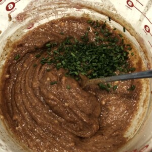 adding chives to sauce